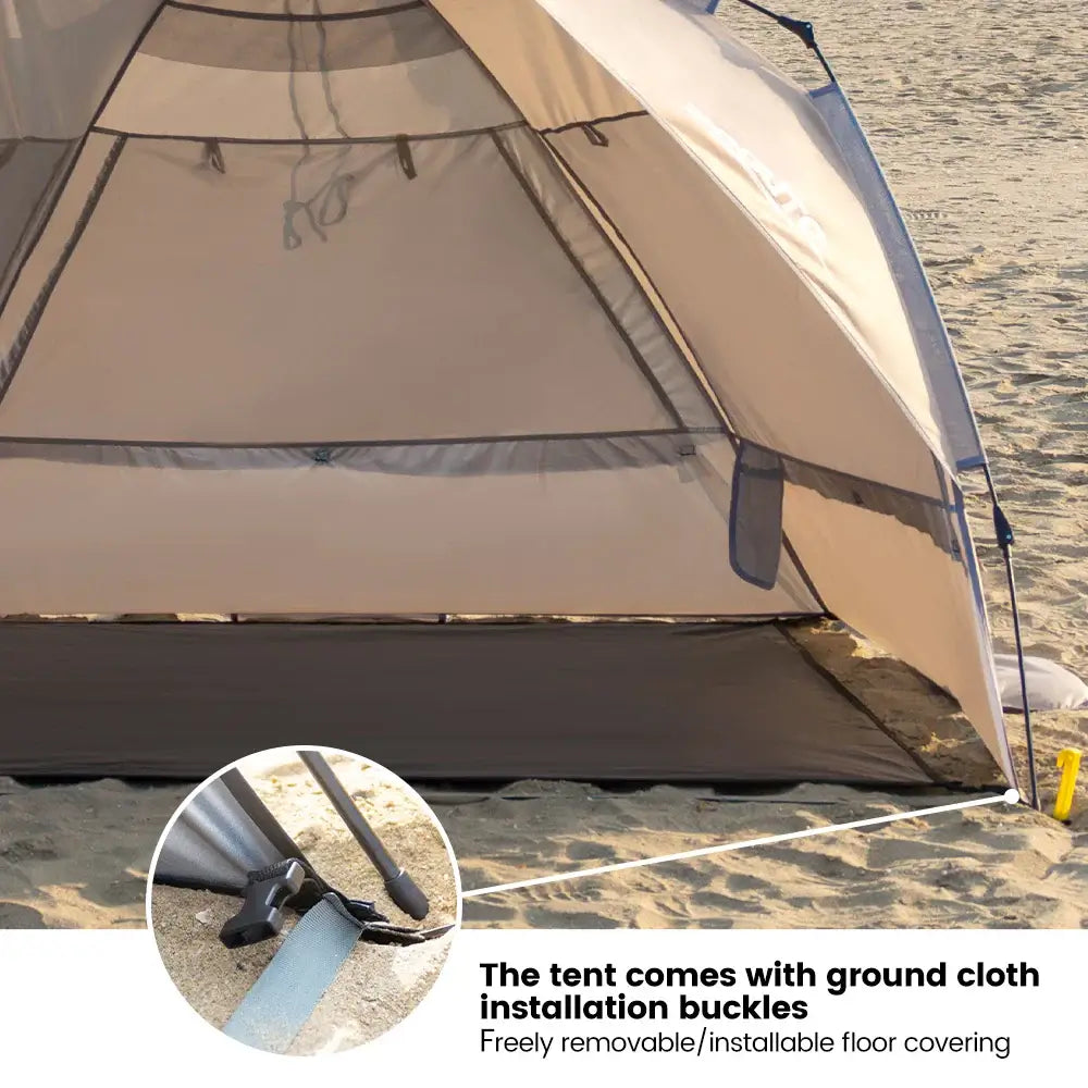 Close-up of outdoor camping tent with installation buckles on sandy beach, featuring removable floor covering for convenience.