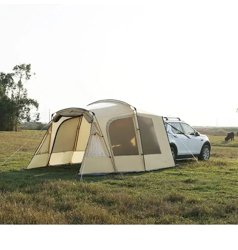 Trunk camping tent set up next to a car on grassy field, designed for Tesla Model Y, waterproof and spacious for 4-6 people.