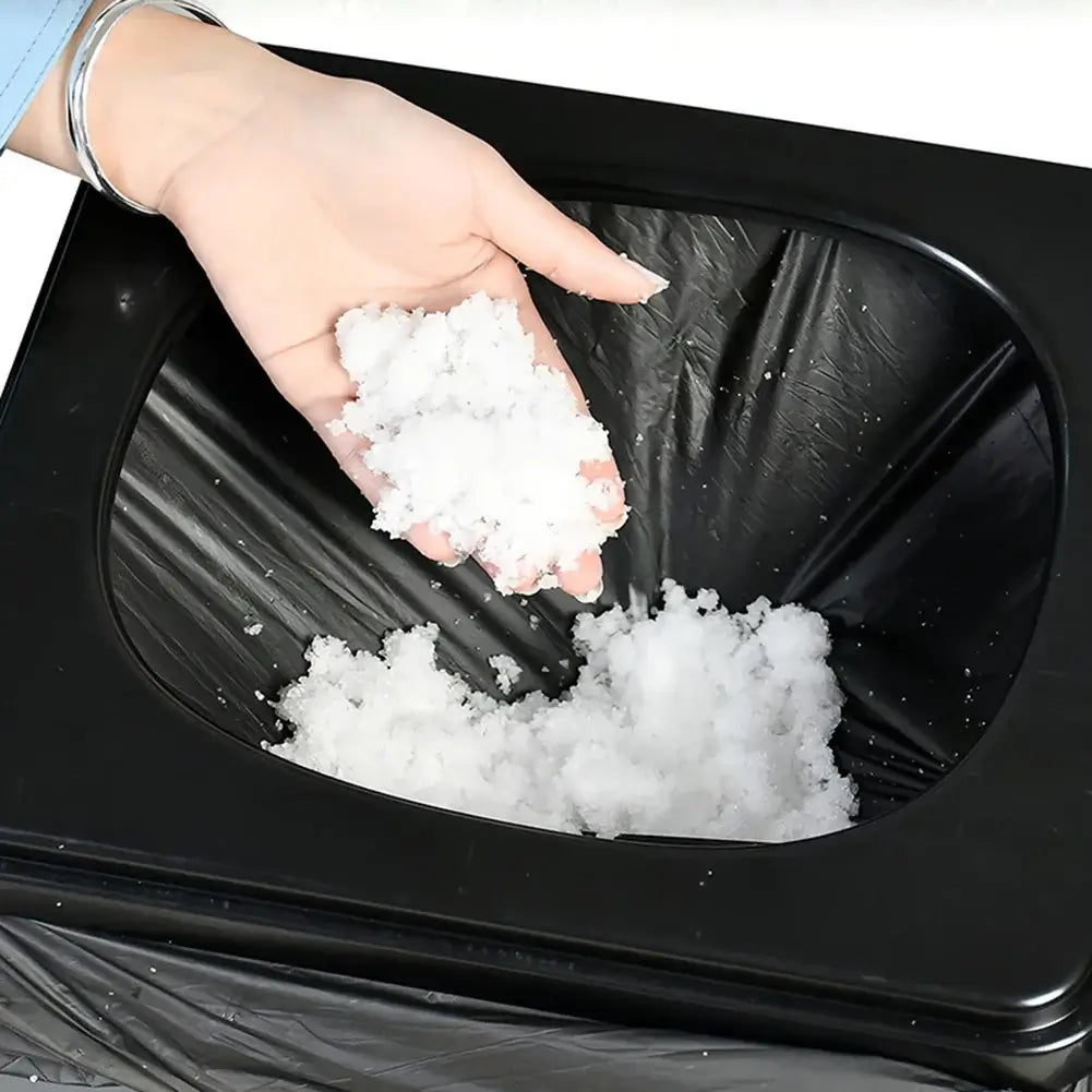 Person holding absorbent camping toilet powder over a portable toilet waste bag for easy disposal.